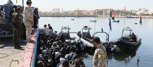 Illegal migrants sit on the dock at the Tripoli port after 115 migrants of African origins were rescued by two coast guard boats at sea when their boat started sinking off the Libyan coast on April 11, 2016 Illegal migrants sit on the dock at the Tripoli port after 115 migrants of African origins were rescued by two coast guard boats at sea when their boat started sinking off the Libyan coast on April 11, 2016 - Sputnik International