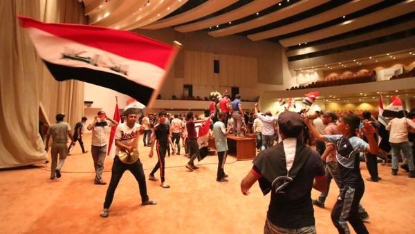 Iraqi protesters wave national flags as they gather inside the parliament after breaking into Baghdad's heavily fortified Green Zone on April 30, 2016 - Sputnik International