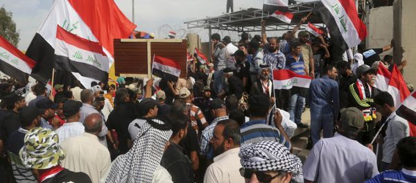 Supporters of Shiite cleric Muqtada al-Sadr walk over the blast walls surrounding Baghdad's highly fortified Green Zone Saturday, April 30, 2016 - Sputnik International