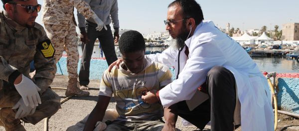 Migrants receive medical treatment in a port, after being rescued at sea by Libyan coast guard, in Tripoli, Libya April 11, 2016 - Sputnik International