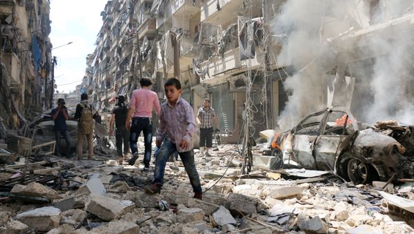 People walk amid the rubble of destroyed buildings following a reported air strike on the rebel-held neighbourhood of al-Kalasa in the northern Syrian city of Aleppo, on April 28, 2016 - Sputnik International