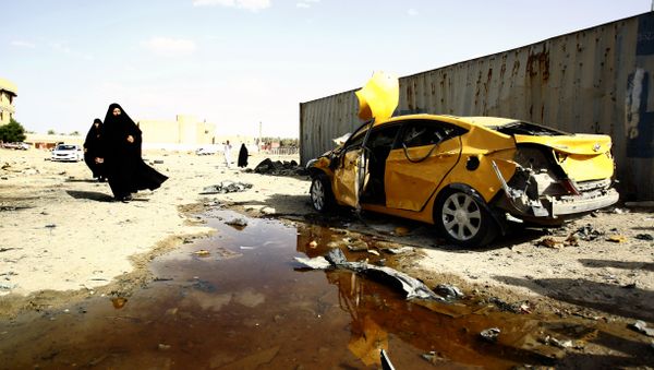 Iraqi women walk past a damaged car following a twin suicide bombing attack, claimed by the Islamic State (IS) group, in the southern Iraqi city of Samawah, situated deep in Iraq's Shiite heartland, on May 1, 2016 Iraqi women walk past a damaged car following a twin suicide bombing attack, claimed by the Islamic State (IS) group, in the southern Iraqi city of Samawah, situated deep in Iraq's Shiite heartland, on May 1, 2016 - Sputnik International
