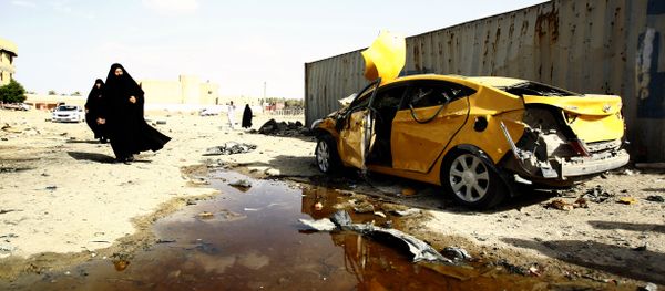 Iraqi women walk past a damaged car following a twin suicide bombing attack, claimed by the Islamic State (IS) group, in the southern Iraqi city of Samawah, situated deep in Iraq's Shiite heartland, on May 1, 2016 Iraqi women walk past a damaged car following a twin suicide bombing attack, claimed by the Islamic State (IS) group, in the southern Iraqi city of Samawah, situated deep in Iraq's Shiite heartland, on May 1, 2016 - Sputnik International