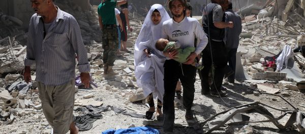 A Syrian family walks amid the rubble of destroyed buildings following a reported airstrike on April 28, 2016 in the Bustan al-Qasr rebel-held district of the northern Syrian city of Aleppo - Sputnik International
