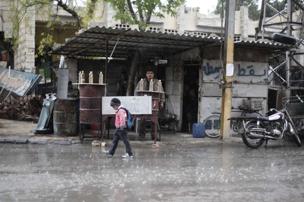 A Syrian schoolboy walks under the rain in Kafr Batna, in the Eastern Ghouta area, on the outskirts of the capital Damascus (File) - Sputnik International