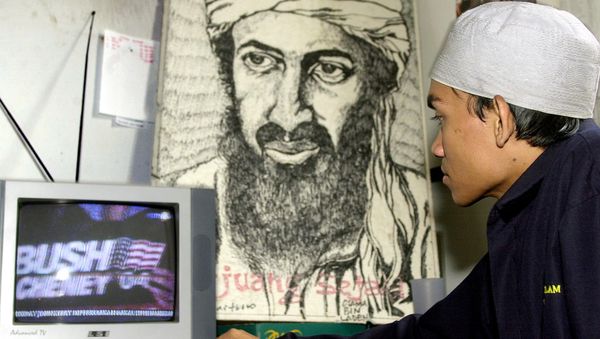 An Indonesian Muslim youth watches a television coverage of the US elections in front of a portrait of Osama bin Laden at a Islam youth movement headquarters in Jakarta, 03 November 2004 - Sputnik International