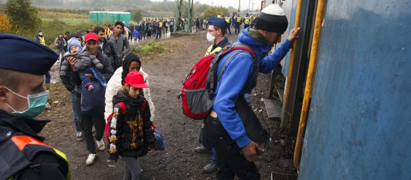 Migrants board a train after making their way through the countryside and crossing the Hungarian-Croatian border near the village of Zakany in Hungary to continue their trip to north on October 16, 2015 Migrants board a train after making their way through the countryside and crossing the Hungarian-Croatian border near the village of Zakany in Hungary to continue their trip to north on October 16, 2015 - Sputnik International