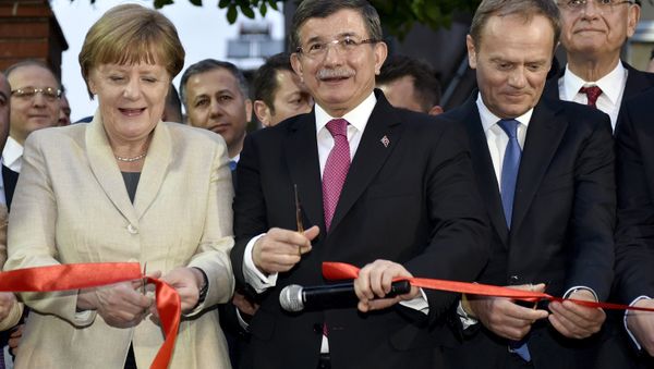 German Chancellor Angela Merkel, Turkish Prime Minister Ahmet Davutoglu and EU Council President Donald Tusk cut a ribbon during a ceremony unveiling a child services center in Nizip refugee camp near Gaziantep, Turkey, April 23, 2016. German Chancellor Angela Merkel, Turkish Prime Minister Ahmet Davutoglu and EU Council President Donald Tusk cut a ribbon during a ceremony unveiling a child services center in Nizip refugee camp near Gaziantep, Turkey, April 23, 2016. - Sputnik International