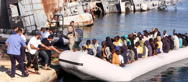 The Libyan coastguard pull a boat carrying illegal African migrants, rescued as they were trying to reach Europe, at a naval base near the capital Tripoli on September 29, 2015. - Sputnik International