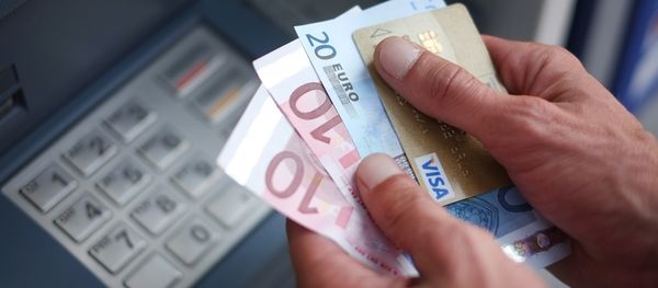 A man takes out Euro banknotes from an automated teller machine (ATM) A man takes out Euro banknotes from an automated teller machine (ATM) - Sputnik International