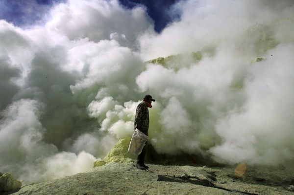 In this Thursday, Aug. 6, 2009 photo, a miner stands against thick volcanic fumes at a sulphur mine at the crater of Ijen volcano in Bayuwangi, East Java, Indonesia - Sputnik International