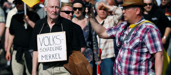 Right-wing protestors demonstrate against refugees, Islam and German Chancellor Angela Merkel in Berlin, Germany, May 7, 2016. The sign reads: Volksschaedling (Enemy of the People) - Sputnik International