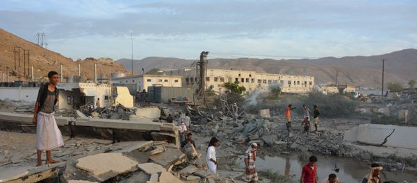 People inspect damage at a site hit by Saudi-led air strikes in the al Qaeda-held port of Mukalla city in southern Yemen April 24, 2016 - Sputnik International