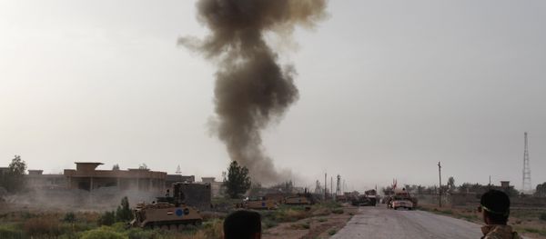 A file photo showing fighters from the Iraqi pro-government forces watch smoke billow during a military operation against Daesh near Amriyat al-Fallujah, west of the capital Baghdad in the Anbar province, on May 5, 2016 - Sputnik International