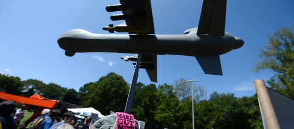Protesters against the use of drone strikes by the US military hold a model of a drone aircraft during the March On Wall Street South rally in Charlotte, North Carolina on September 2, 2012. - Sputnik International