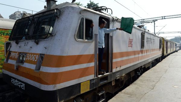 In this photograph taken on December 9, 2015, an Indian locomotive driver of the Ahmedabad bound Karnavati Express waves a green flag as he signals the depature of the train from Mumbai Central railway station in Mumbai - Sputnik International