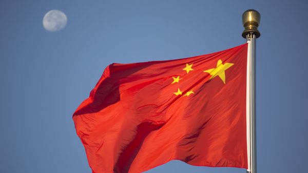 The moon sets above a Chinese flag flying over Tiananmen Square after a flag raising ceremony on National Day, the 66th anniversary of the founding of the People's Republic of China, in Beijing, Thursday, Oct. 1, 2015 - Sputnik International