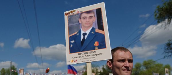 A participant carries a photo of Hero of Russia Alexander Prokhorenko killed in Syria, during the Immortal Regiment march on the 71st anniversary of Victory in WWII in Orenburg A participant carries a photo of Hero of Russia Alexander Prokhorenko killed in Syria, during the Immortal Regiment march on the 71st anniversary of Victory in WWII in Orenburg - Sputnik International