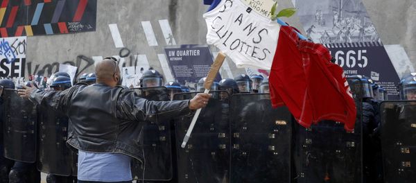 A man holds a French flag with the message, No to the El Khomri law in front of a line of French riot police during a protest against the French labour law proposal during the May Day labour union march in Paris, France, May 1, 2016. - Sputnik International