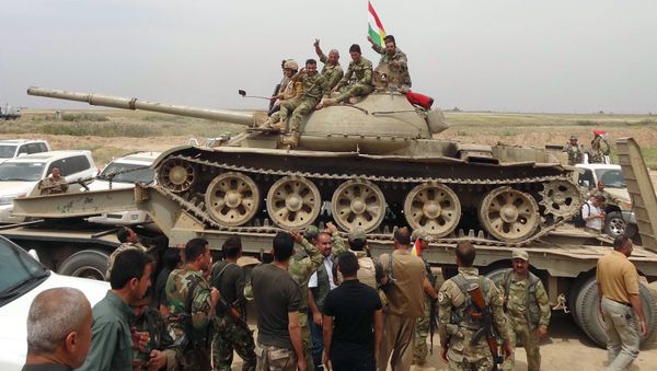 Iraqi Kurdish and Turkmen Shiite forces from the Popular Mobilisation units sit on top of a tank on May 1, 2016 in the northern Iraqi town of al-Bashir after they recaptured the town from the control of the Islamic State (IS) group Iraqi Kurdish and Turkmen Shiite forces from the Popular Mobilisation units sit on top of a tank on May 1, 2016 in the northern Iraqi town of al-Bashir after they recaptured the town from the control of the Islamic State (IS) group - Sputnik International