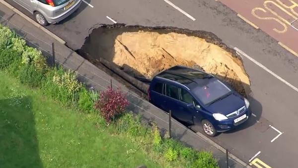 Car teeters on the edge of giant sinkhole, London - Sputnik International
