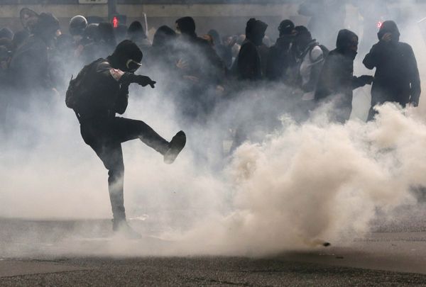 A protester kicks back a teargas grenade during a demonstration against French labour law reform in Paris, France, May 12, 2016. - Sputnik International