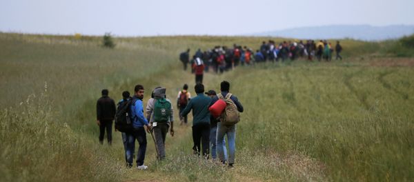 A group of migrants and refugees who stayed in Idomeni makeshift camp walks through a field in attempt to cross the Greek-Macedonian border near the village of Evzoni, Greece, May 12, 2016. A group of migrants and refugees who stayed in Idomeni makeshift camp walks through a field in attempt to cross the Greek-Macedonian border near the village of Evzoni, Greece, May 12, 2016. - Sputnik International