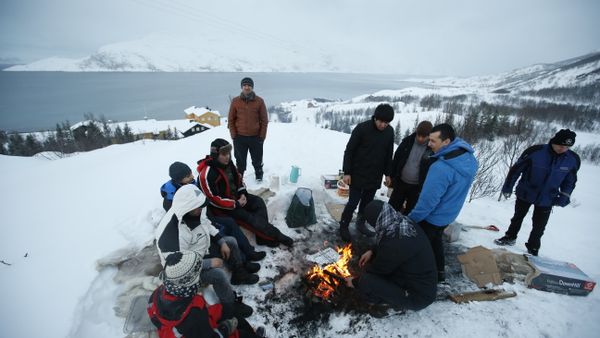 Asylum seekers gather round a fire as they cook a meal overlooking the temporary Altnes camp refugee camp on the island of Seiland, northern Norway (File) - Sputnik International
