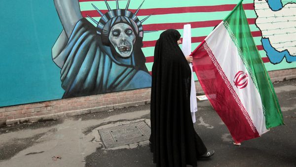 An Iranian woman holds her national flag as she walks past an anti-US mural depicting the Statue of Liberty on the wall of the former US embassy in Tehran (File) An Iranian woman holds her national flag as she walks past an anti-US mural depicting the Statue of Liberty on the wall of the former US embassy in Tehran (File) - Sputnik International