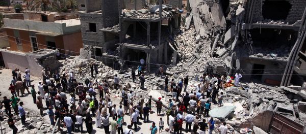 Libyans gather next to the rubble of buildings the Libyan authorities said were damaged by airstrikes on Tripoli's residential district of Arada (File) Libyans gather next to the rubble of buildings the Libyan authorities said were damaged by airstrikes on Tripoli's residential district of Arada (File) - Sputnik International