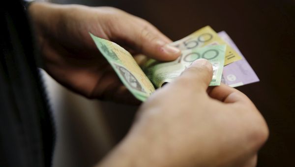 A customer counts his Australian dollar banknotes (File) A customer counts his Australian dollar banknotes (File) - Sputnik International