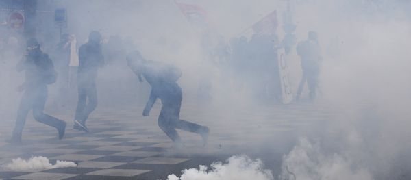 Protesters run from tear gas canisters during clashes with police at a demonstration after the French government used the constitution's Article 49,3 to bypass parliament and force through a controversial labour reform bill, on May 17, 2016, in Paris - Sputnik International