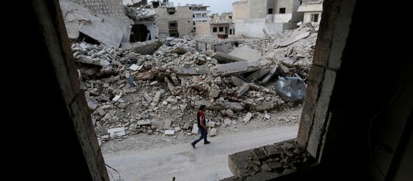 A man walks past damaged buildings in the rebel-controlled area of Maaret al-Numan town in Idlib province, Syria, May 15, 2016 - Sputnik International
