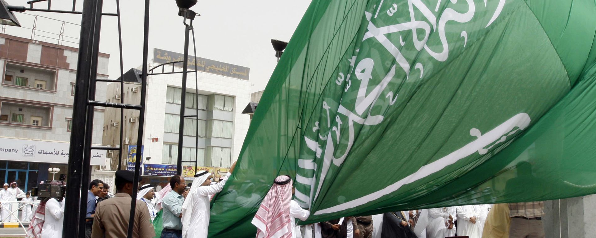 Saudi men unfurl a giant Saudi national flag during a ceremony to raise the highest flag in the country in the eastern city of Dammam on June 17, 2008 Saudi men unfurl a giant Saudi national flag during a ceremony to raise the highest flag in the country in the eastern city of Dammam on June 17, 2008 - Sputnik International, 1920, 17.01.2022