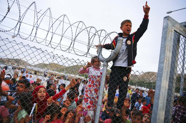Refugee youths gesture from behind a fence at Nizip refugee camp near Gaziantep, Turkey, April 23, 2016. Refugee youths gesture from behind a fence at Nizip refugee camp near Gaziantep, Turkey, April 23, 2016. - Sputnik International