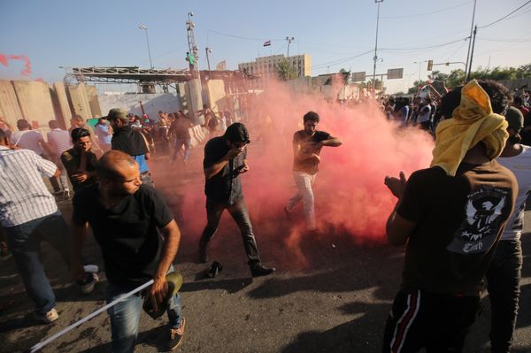 Supporters of Iraqi cleric Moqtada al-Sadr flee the smoke grenades fired by security forces during clashes after demonstrators broke into Baghdad's fortified Green Zone on May 20, 2016 Supporters of Iraqi cleric Moqtada al-Sadr flee the smoke grenades fired by security forces during clashes after demonstrators broke into Baghdad's fortified Green Zone on May 20, 2016 - Sputnik International