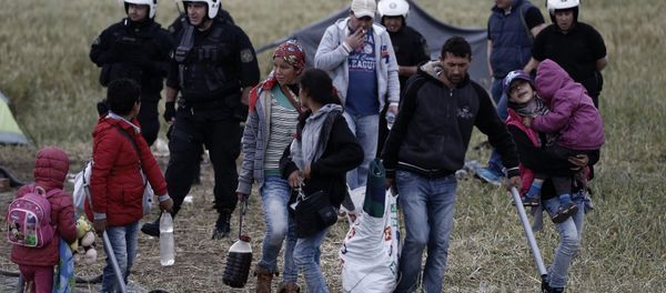 A migrant family carries their belongings during an evacuation operation by police forces of a makeshift migrant camp at the border at the Greek-Macedonian border near the village of Idomeni, on May 24, 2016 A migrant family carries their belongings during an evacuation operation by police forces of a makeshift migrant camp at the border at the Greek-Macedonian border near the village of Idomeni, on May 24, 2016 - Sputnik International