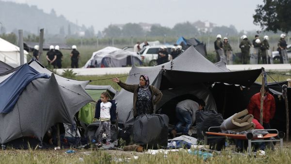 A migrant family stands outside their tent during an evacuation operation by police forces of a makeshift migrant camp at the border at the Greek-Macedonian border near the village of Idomeni, on May 24, 2016 A migrant family stands outside their tent during an evacuation operation by police forces of a makeshift migrant camp at the border at the Greek-Macedonian border near the village of Idomeni, on May 24, 2016 - Sputnik International