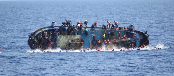 Migrants are seen on a capsizing boat before a rescue operation by Italian navy ships Bettica and Bergamini off the coast of Libya in this handout picture released by the Italian Marina Militare on May 25, 2016 - Sputnik International