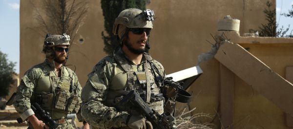 Armed men in uniform identified by Syrian Democratic forces as US special operations forces walk in the village of Fatisah in the northern Syrian province of Raqa on May 25, 2016 - Sputnik International