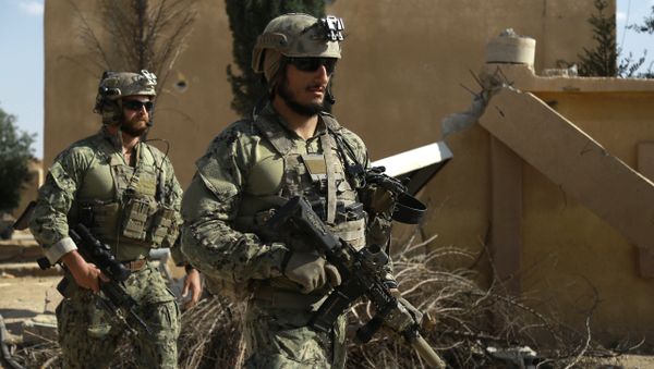 Armed men in uniform identified by Syrian Democratic forces as US special operations forces walk in the village of Fatisah in the northern Syrian province of Raqa on May 25, 2016 - Sputnik International