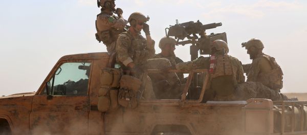 Armed men in uniform identified by Syrian Democratic forces as US special operations forces ride in the back of a pickup truck in the village of Fatisah in the northern Syrian province of Raqa on May 25, 2016 - Sputnik International