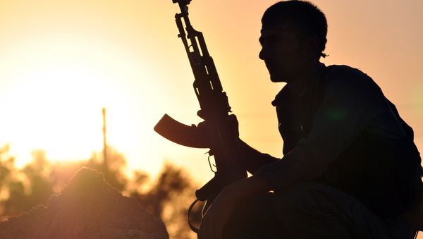 A fighter from the Kurdish People Protection Unit (YPG) poses for a photo at sunset in the Syrian town of Ain Issi, some 50 kilometres north of Raqqa, the self-proclaimed capital of the Islamic State (IS) group during clashes between IS group jihadists and YPG fighters on July 10, 2015 A fighter from the Kurdish People Protection Unit (YPG) poses for a photo at sunset in the Syrian town of Ain Issi, some 50 kilometres north of Raqqa, the self-proclaimed capital of the Islamic State (IS) group during clashes between IS group jihadists and YPG fighters on July 10, 2015 - Sputnik International