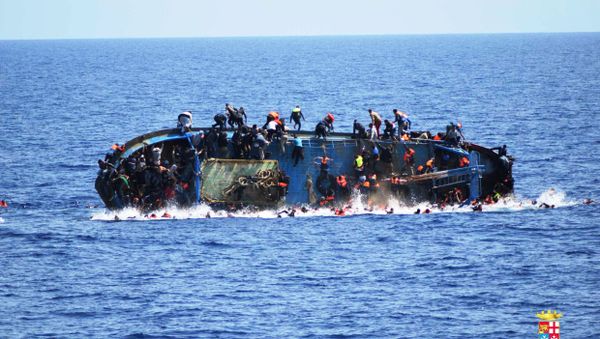 Migrants are seen on a capsizing boat before a rescue operation by Italian navy ships Bettica and Bergamini off the coast of Libya in this handout picture released by the Italian Marina Militare on May 25, 2016. - Sputnik International