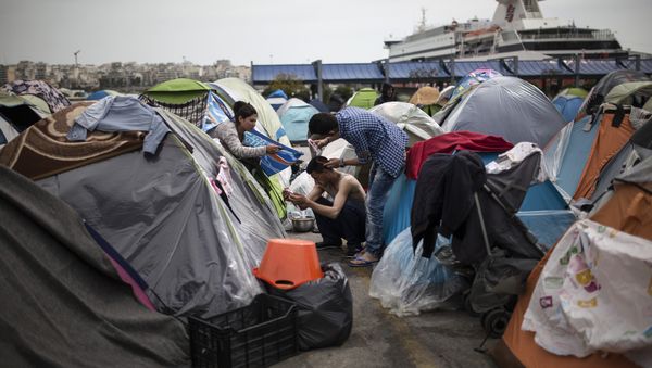 A man cuts another man's hair outside a passenger terminal used as a shelter for refugees and migrants at the Piraeus harbour in Athens on April 3, 2016 A man cuts another man's hair outside a passenger terminal used as a shelter for refugees and migrants at the Piraeus harbour in Athens on April 3, 2016 - Sputnik International