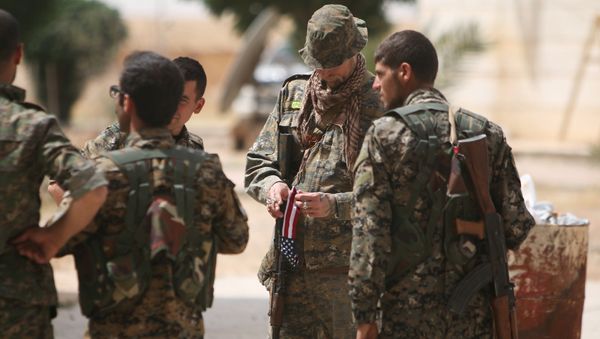 A US fighter, who is fighting alongside with Syria Democratic Forces (SDF), carries his national flag as he stands with SDF fighters in northern province of Raqqa, Syria May 27, 2016 - Sputnik International