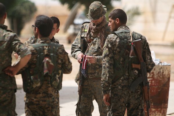 A US fighter, who is fighting alongside with Syria Democratic Forces (SDF), carries his national flag as he stands with SDF fighters in northern province of Raqqa, Syria May 27, 2016 - Sputnik International