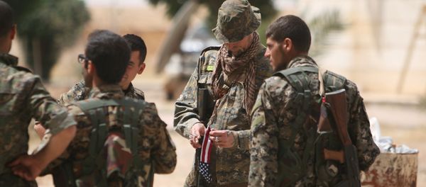 A US fighter, who is fighting alongside with Syria Democratic Forces (SDF), carries his national flag as he stands with SDF fighters in northern province of Raqqa, Syria May 27, 2016 - Sputnik International