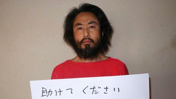 This undated picture provided by Japan's Jiji Press news agency, taken at an undisclosed location, on May 30, 2016 shows Japanese freelance journalist Jumpei Yasuda holding a piece of paper with a handwritten message in Japanese. The fresh photo, which received widespread coverage in Japanese media on May 30, 2016, shows Yasuda, who has been missing for almost a year, wearing an orange shirt, his hair and beard grown long. - Sputnik International