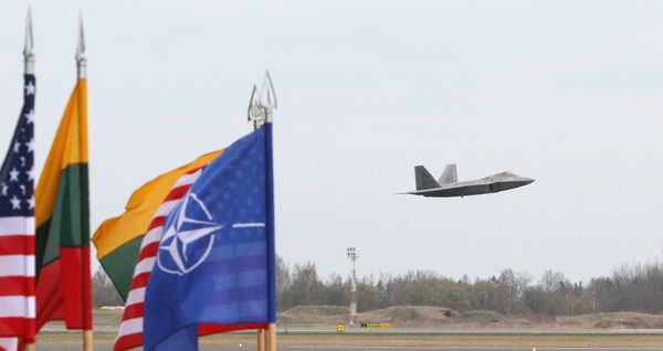 A US Air Force F-22 Raptor fighter aircraft flies at the Air Base of the Lithuanian Armed Forces in Šiauliai, Lithuania, on April 27, 2016 behind flags of US, Lithiania and the NATO A US Air Force F-22 Raptor fighter aircraft flies at the Air Base of the Lithuanian Armed Forces in Šiauliai, Lithuania, on April 27, 2016 behind flags of US, Lithiania and the NATO - Sputnik International